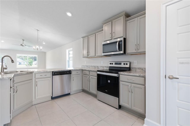 kitchen with light stone countertops, sink, stainless steel appliances, gray cabinets, and light tile patterned flooring