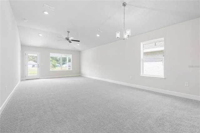 empty room with ceiling fan with notable chandelier, carpet flooring, and lofted ceiling