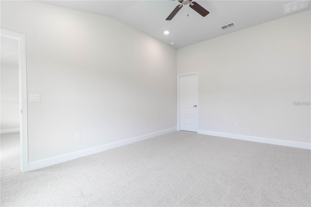 empty room featuring light carpet, vaulted ceiling, and ceiling fan