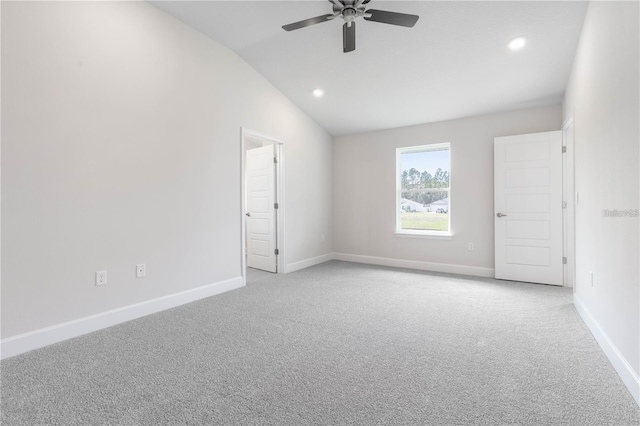 spare room with ceiling fan, light colored carpet, and vaulted ceiling