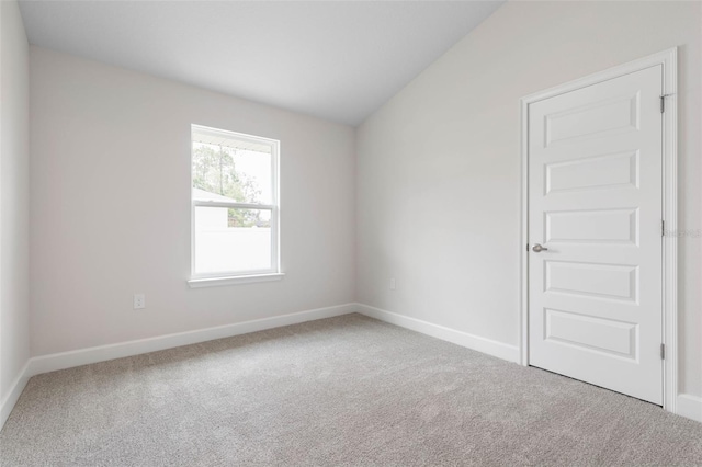 48 Bannbury Ln, Palm Coast, FL 32137 - spare room featuring carpet, baseboards, and vaulted ceiling
