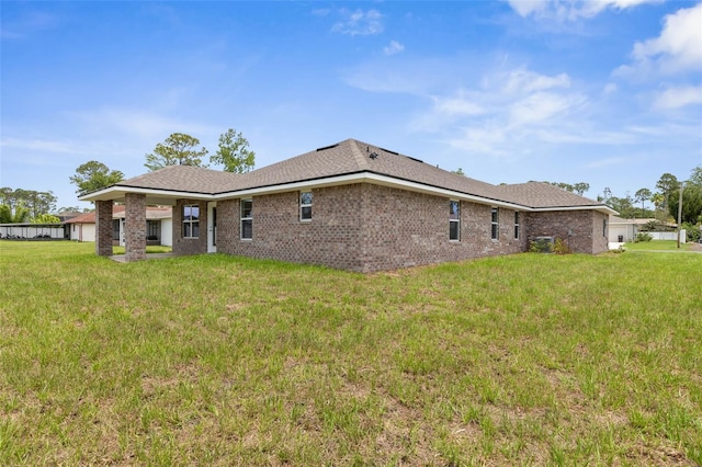 48 Bannbury Ln, Palm Coast, FL 32137 - back of house with a lawn and brick siding