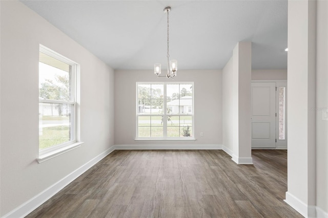 48 Bannbury Ln, Palm Coast, FL 32137 - unfurnished dining area with dark wood-style floors, a chandelier, and baseboards