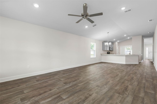 48 Bannbury Ln, Palm Coast, FL 32137 - unfurnished living room featuring vaulted ceiling, a chandelier, healthy amount of natural light, dark wood finished floors, and ceiling fan