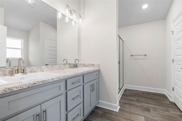 48 Bannbury Ln, Palm Coast, FL 32137 - full bathroom with double vanity, baseboards, wood finished floors, a shower stall, and recessed lighting