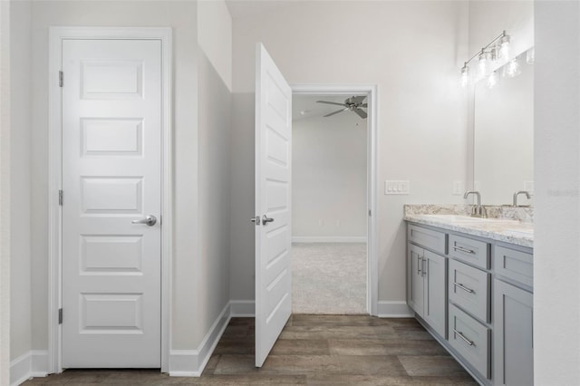 48 Bannbury Ln, Palm Coast, FL 32137 - full bath with double vanity, a ceiling fan, wood finished floors, and baseboards