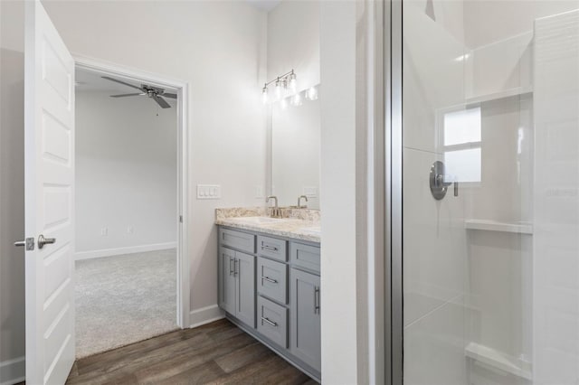 48 Bannbury Ln, Palm Coast, FL 32137 - full bath with double vanity, wood finished floors, an enclosed shower, a ceiling fan, and baseboards