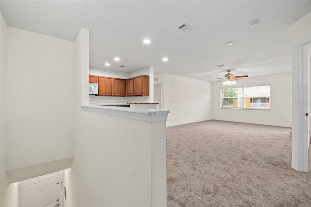 unfurnished living room with light carpet and ceiling fan