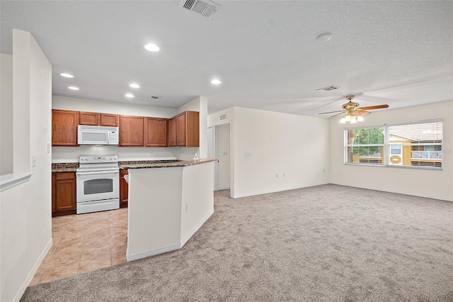 kitchen featuring white appliances, light colored carpet, and ceiling fan