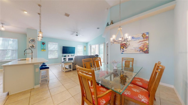 tiled dining area with vaulted ceiling, ceiling fan with notable chandelier, and sink