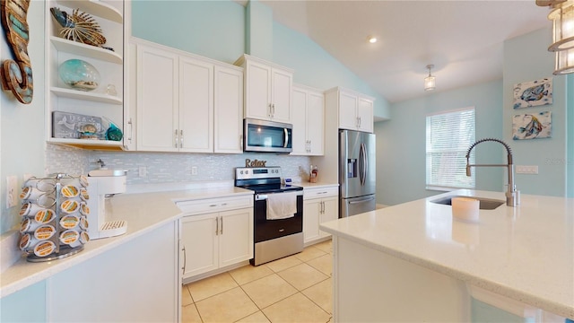 kitchen featuring tasteful backsplash, white cabinetry, appliances with stainless steel finishes, and sink