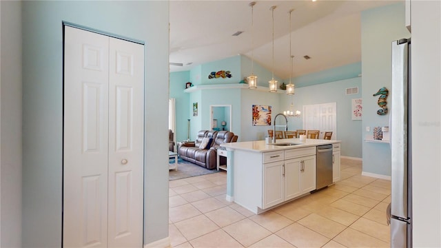 kitchen with sink, white cabinetry, stainless steel appliances, a center island with sink, and decorative light fixtures