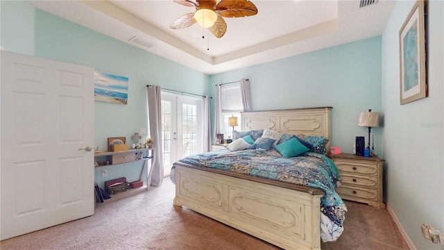 carpeted bedroom with french doors, ceiling fan, access to exterior, and a raised ceiling