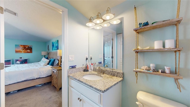 bathroom with vanity, lofted ceiling, and toilet