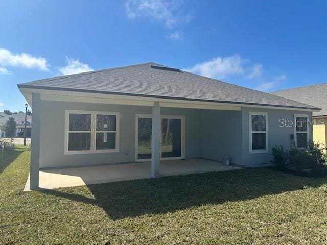 rear view of property featuring a patio area and a lawn