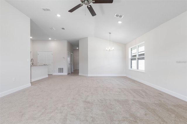 unfurnished living room featuring ceiling fan with notable chandelier, light colored carpet, and lofted ceiling