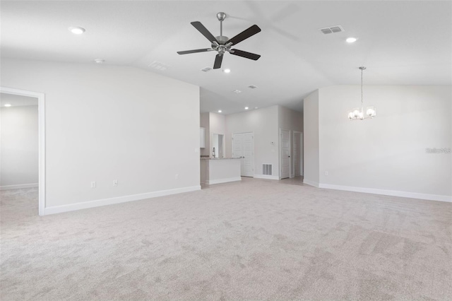 unfurnished living room featuring ceiling fan with notable chandelier, light colored carpet, and lofted ceiling