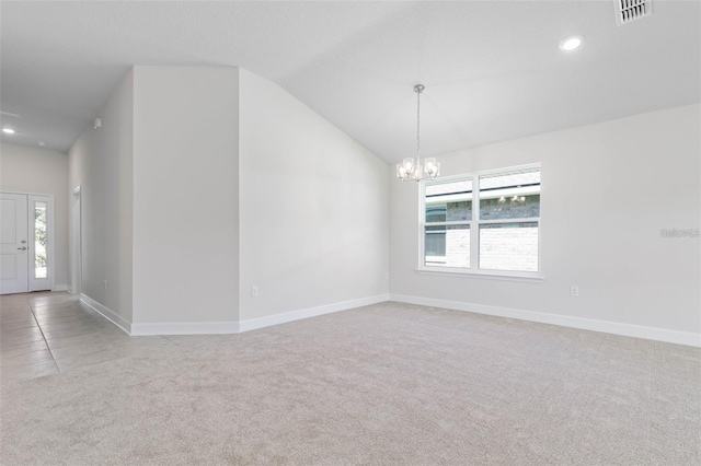 carpeted empty room with lofted ceiling, a healthy amount of sunlight, and an inviting chandelier