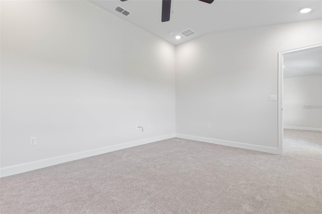 spare room featuring ceiling fan, light carpet, and lofted ceiling