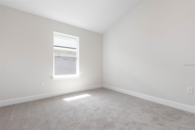 empty room with carpet flooring and vaulted ceiling