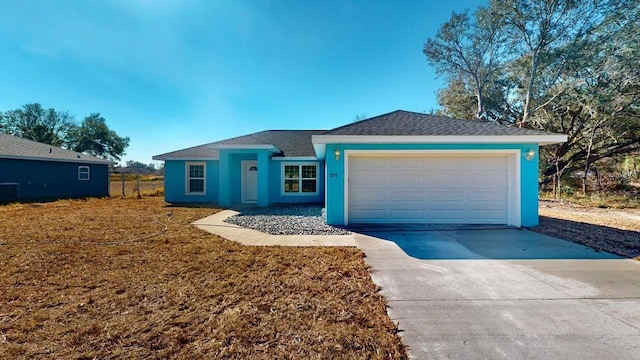 ranch-style home with central AC unit and a garage