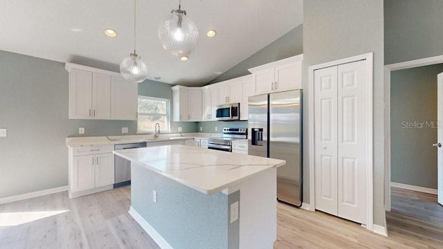 kitchen with white cabinetry, decorative light fixtures, a center island, stainless steel appliances, and light hardwood / wood-style floors