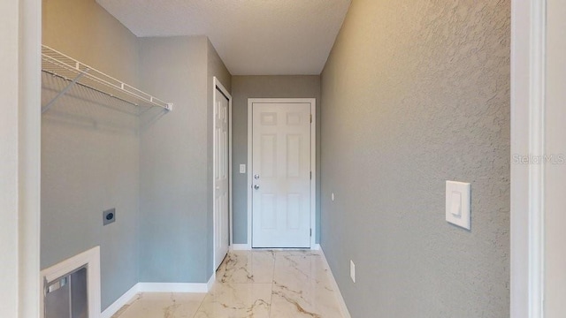 clothes washing area with electric dryer hookup and a textured ceiling