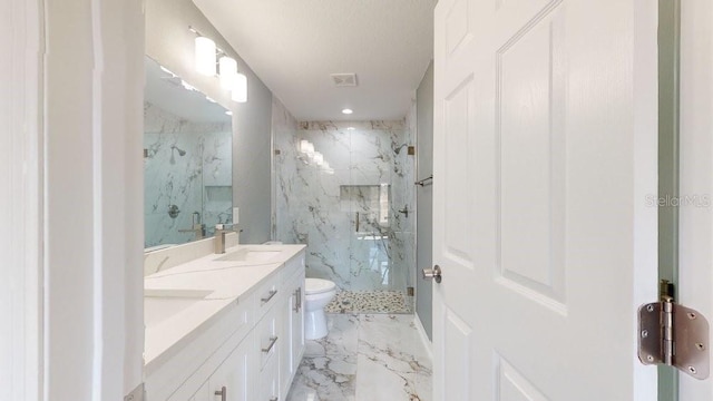 bathroom with toilet, vanity, and a shower with shower door