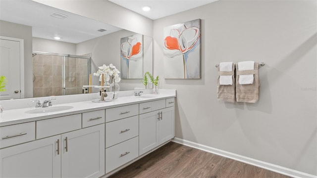 bathroom with hardwood / wood-style floors, walk in shower, and vanity