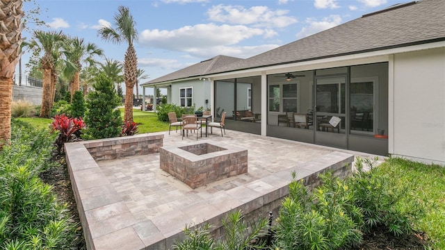 view of patio / terrace with a sunroom, an outdoor fire pit, and ceiling fan