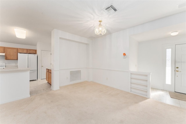 unfurnished living room featuring light carpet and a notable chandelier