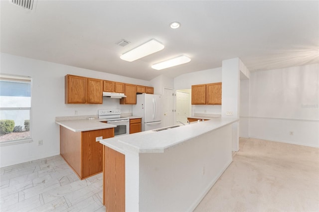 kitchen featuring lofted ceiling, sink, kitchen peninsula, a kitchen island, and white appliances