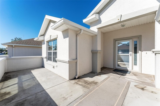 view of exterior entry with a patio area