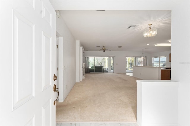 interior space featuring ceiling fan with notable chandelier