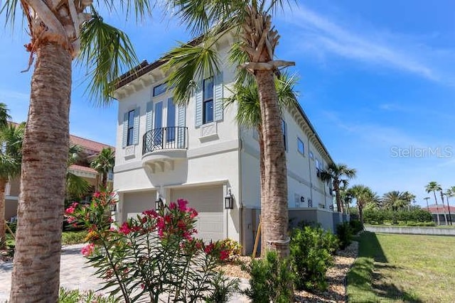 view of home's exterior featuring a balcony and a garage