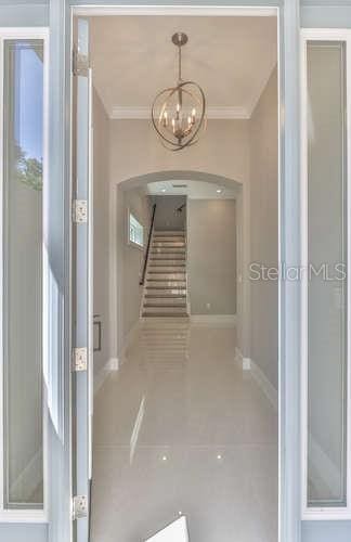 corridor featuring crown molding and tile patterned floors