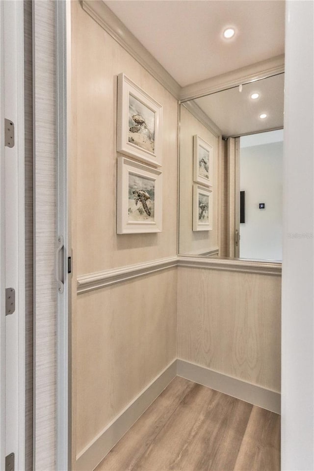 hallway featuring ornamental molding and hardwood / wood-style floors