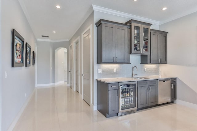 bar featuring sink, light stone counters, dark brown cabinets, dishwasher, and beverage cooler