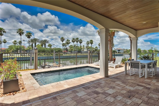 view of pool featuring a patio and a water view