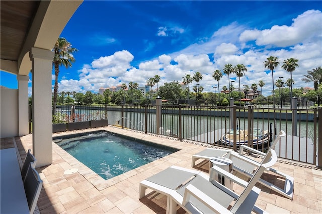 view of pool with a patio and a water view