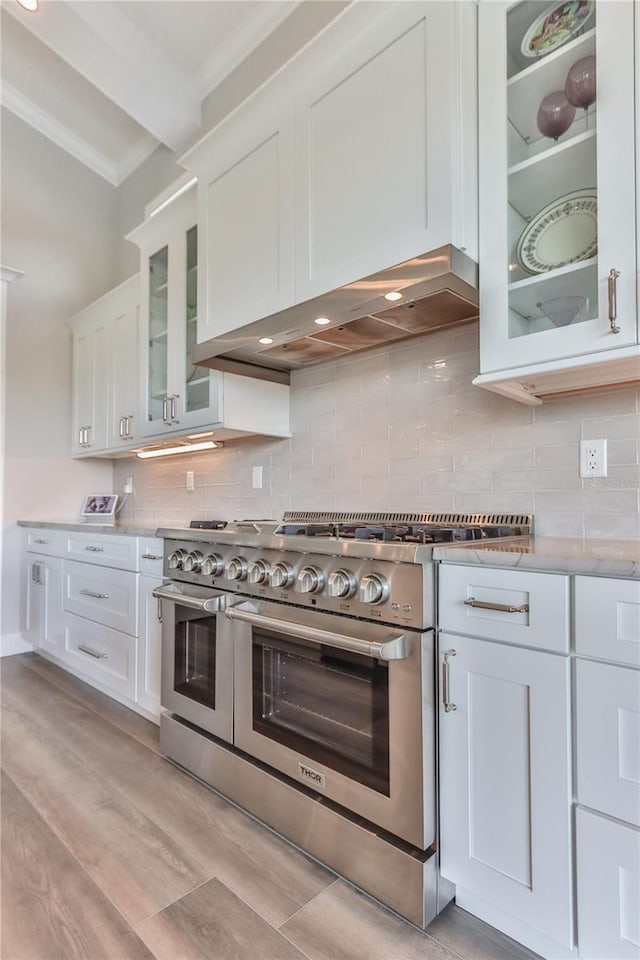 kitchen featuring white cabinetry, decorative backsplash, double oven range, crown molding, and light hardwood / wood-style flooring