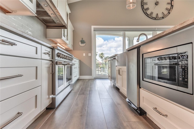 kitchen featuring wall oven, dark wood-type flooring, and white cabinets