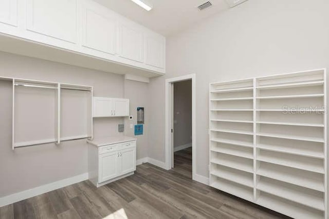 spacious closet with dark hardwood / wood-style flooring