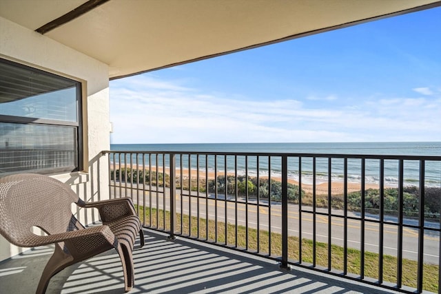 balcony featuring a beach view and a water view