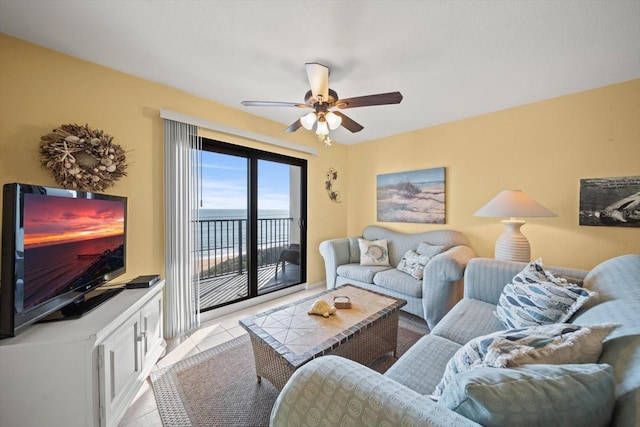 tiled living room featuring a water view and ceiling fan