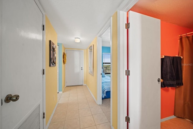 hall featuring light tile patterned flooring