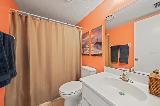 bathroom with vanity, tile patterned floors, toilet, and a textured ceiling