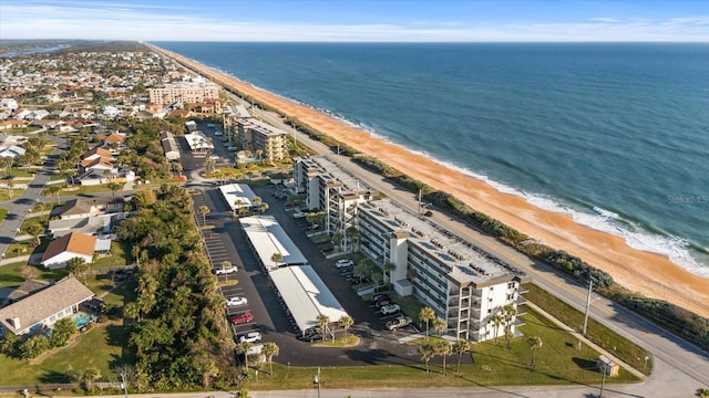 birds eye view of property with a water view and a beach view