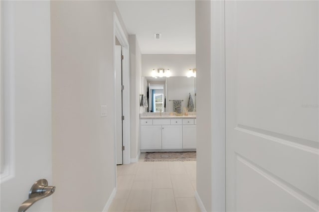 corridor with sink and light tile patterned floors