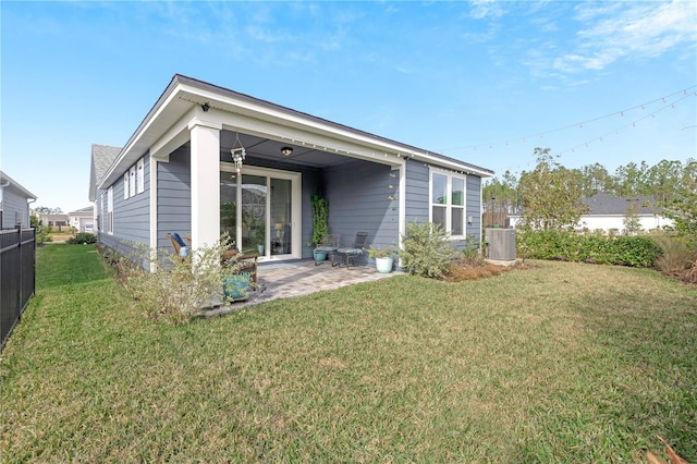 rear view of property featuring a yard, a patio area, and central air condition unit